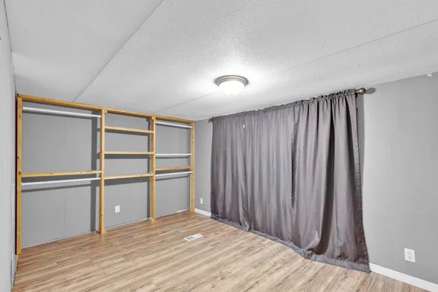 a view of a kitchen with a closet and wooden floor