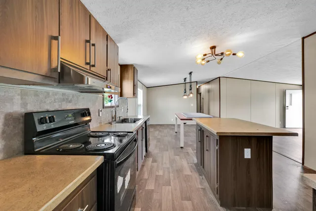 a kitchen with a stove and a wooden floors
