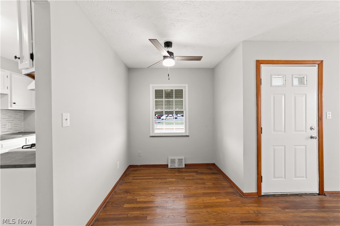 4907 Ridge Road Cleveland, OH 44144 - Photo 7 of 36 Unfurnished room with a textured ceiling, ceiling fan, and dark wood-type flooring