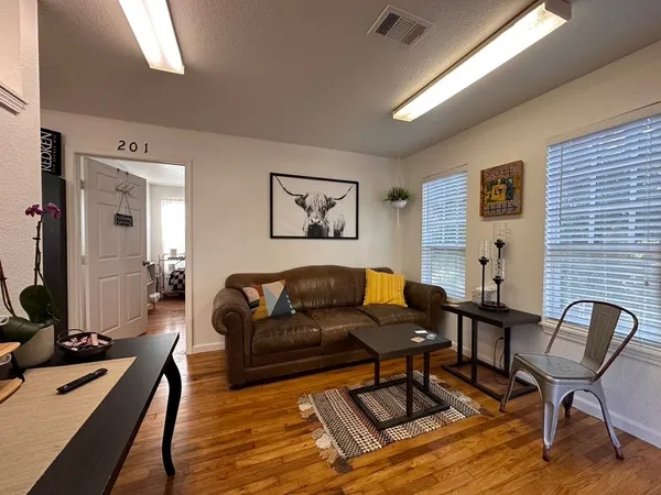 a living room with furniture and wooden floor