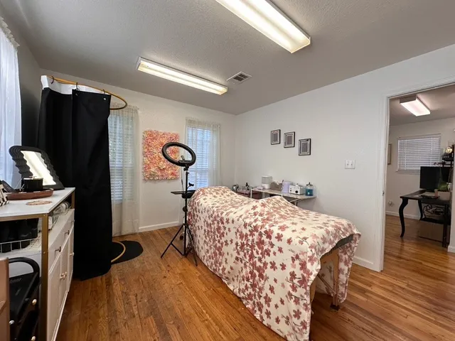 a bedroom with a bed and a flat tv screen on the dresser
