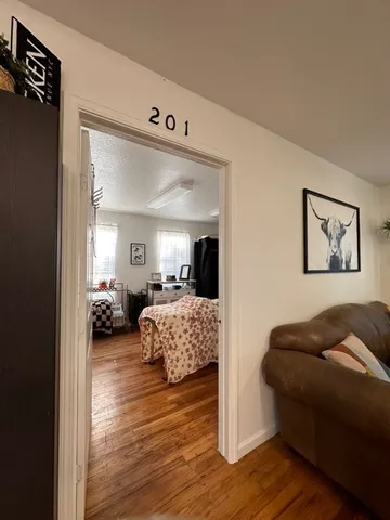 a bedroom with furniture and a wooden floor