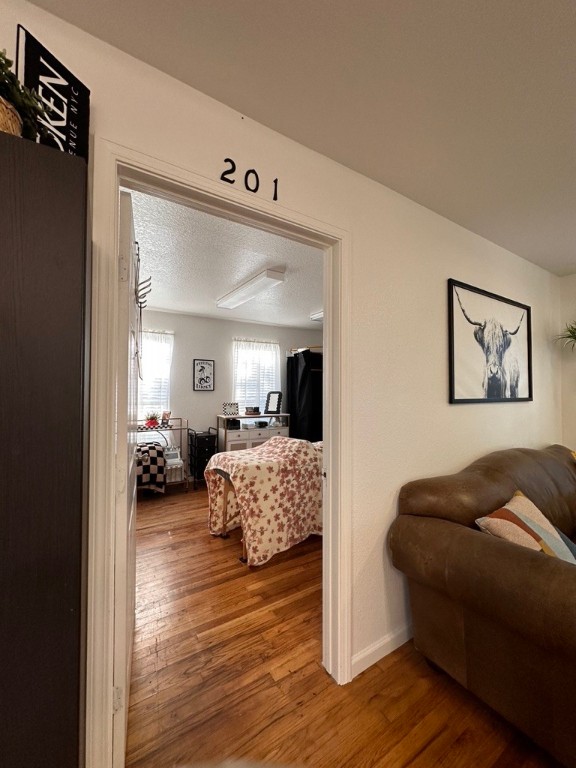 208 West 10th Street, Unit 201 Georgetown, TX 78626 - Photo 18 of 18 a bedroom with furniture and a wooden floor