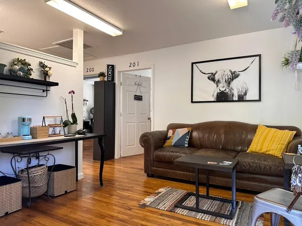 a living room with furniture and a wooden floor