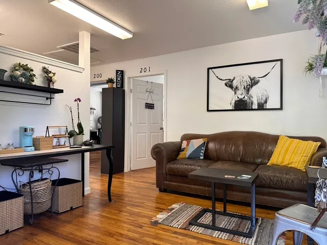a living room with furniture and a wooden floor