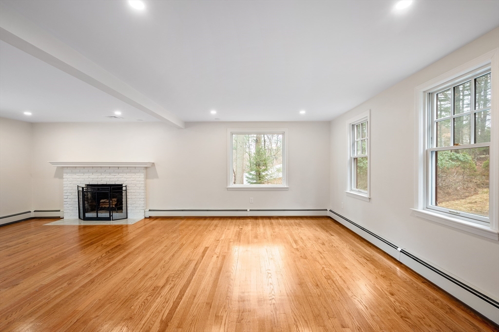 115 Brook Bend Road Hanover, MA 02339 - Photo 17 of 42 wooden floor fireplace and windows in an empty room