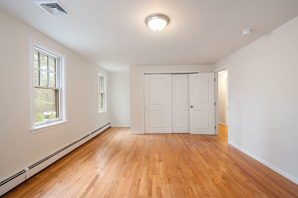 115 Brook Bend Road Hanover, MA 02339 - Photo 25 of 42 an empty room with wooden floor and windows