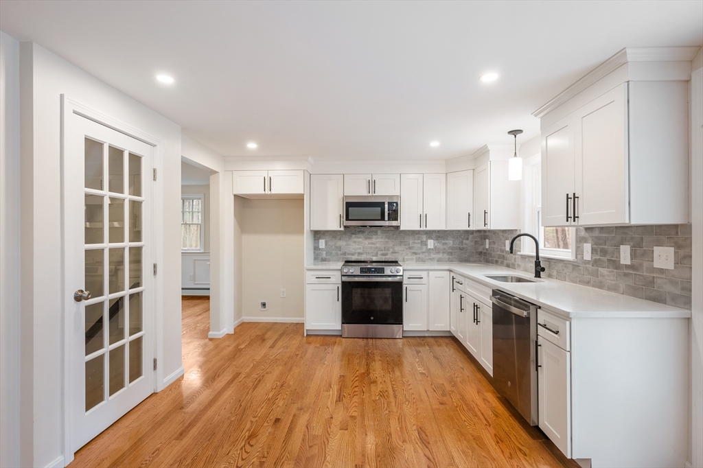 115 Brook Bend Road Hanover, MA 02339 - Photo 3 of 42 a large kitchen with stainless steel appliances granite countertop a stove top oven a sink dishwasher and a refrigerator with wooden floor