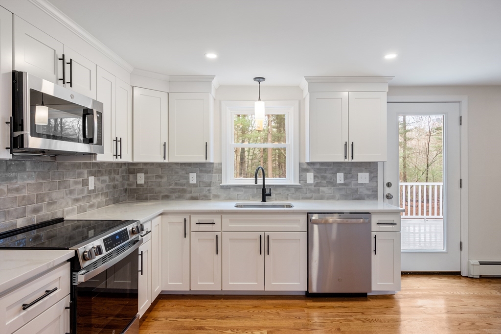 115 Brook Bend Road Hanover, MA 02339 - Photo 4 of 42 a kitchen with stainless steel appliances granite countertop a sink and stove top oven