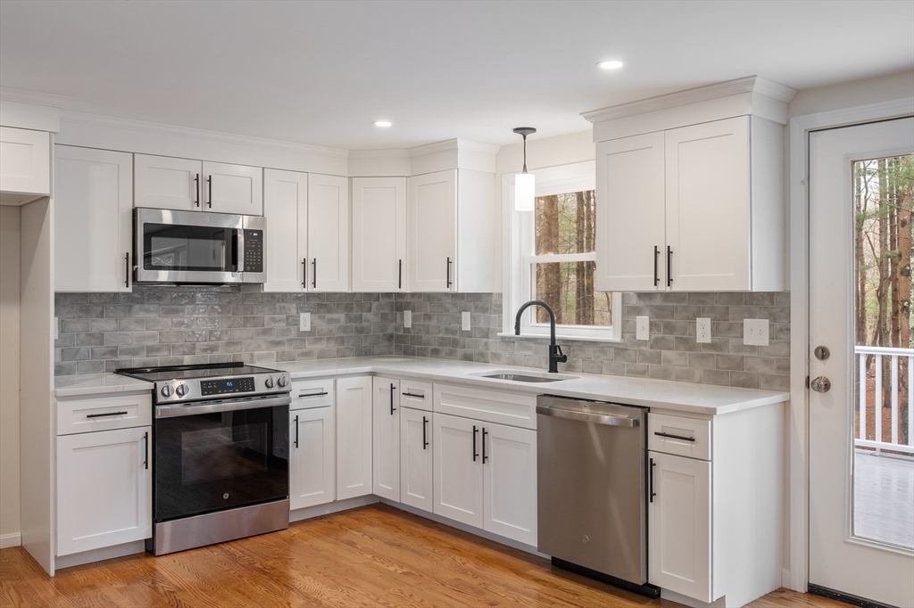 115 Brook Bend Road Hanover, MA 02339 - Photo 5 of 42 a kitchen with stainless steel appliances granite countertop a stove top oven a sink and dishwasher with white cabinets