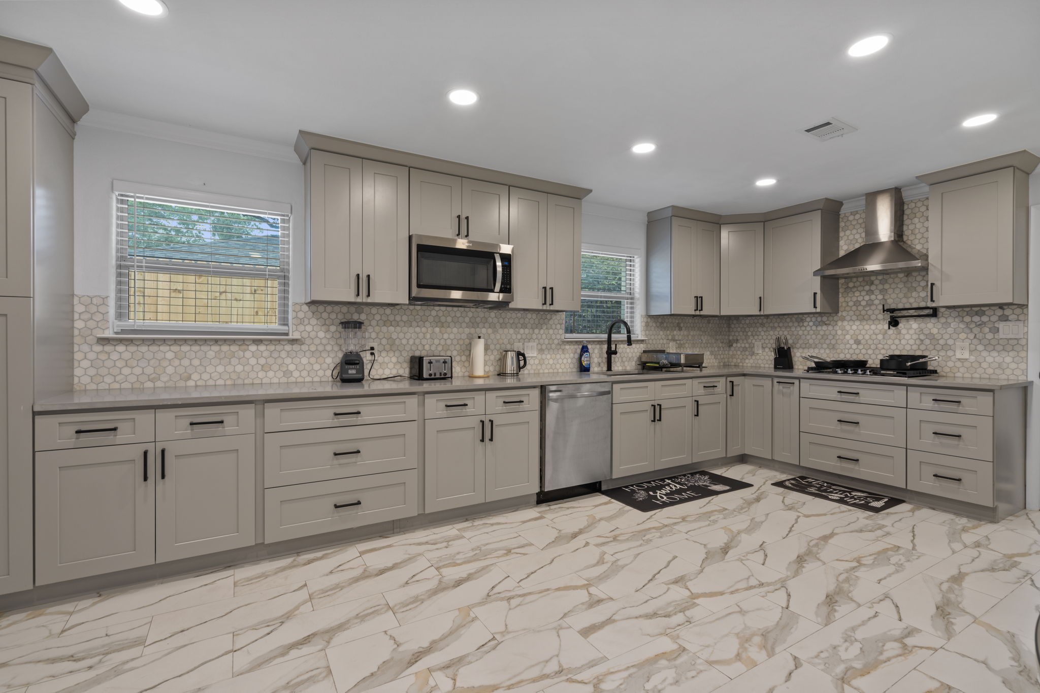 2402 Chimney Rock Road Houston, TX 77057 - Photo 5 of 36 Beautifully updated kitchen with a bright, open feel and modern finishes. Features shaker cabinets, stainless steel appliances, and a designer backsplash, all complemented by a clean, neutral design.