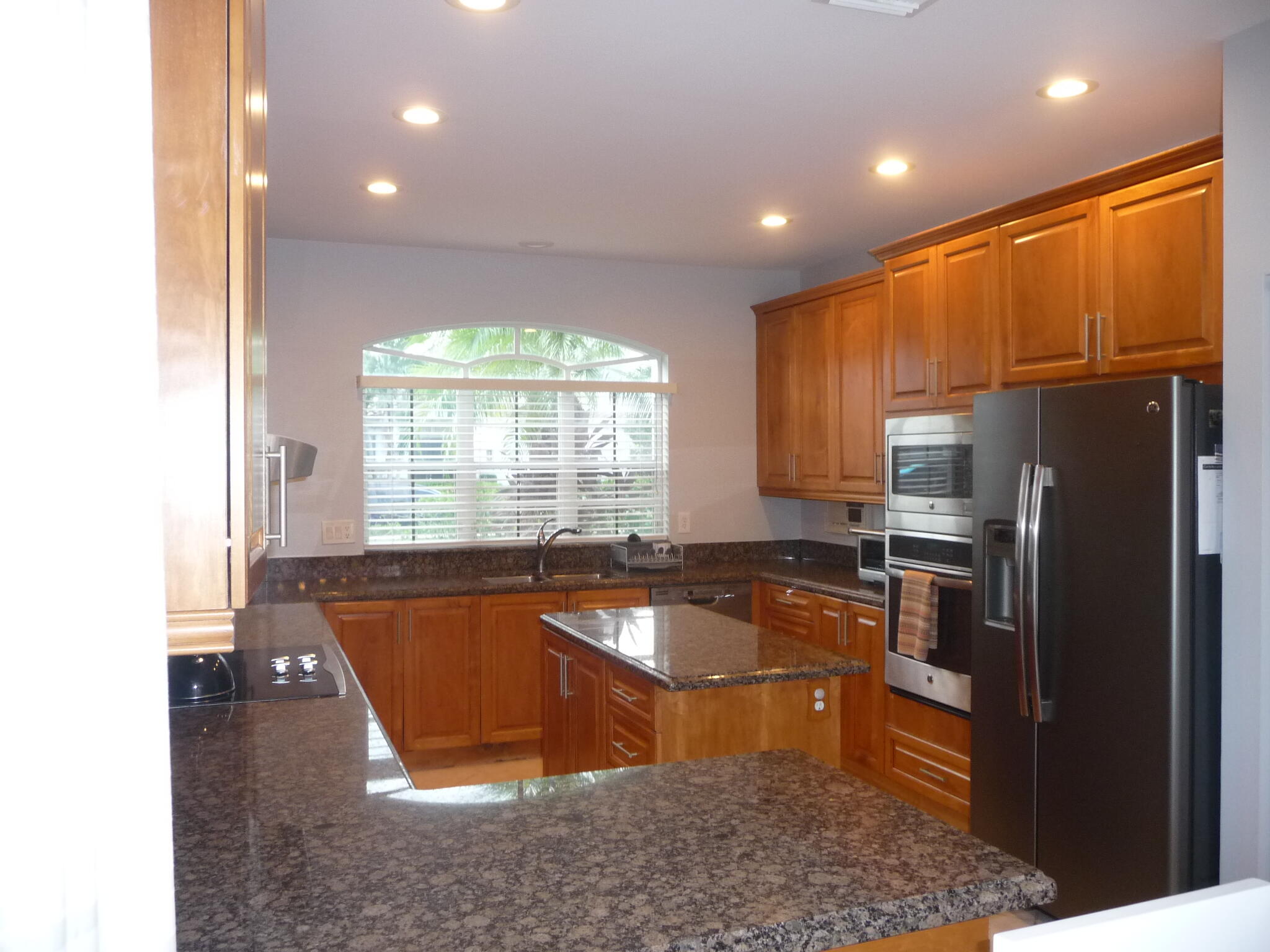 20694 Northwest 27th Avenue Boca Raton, FL 33434 - Photo 3 of 22 a large kitchen with granite countertop a refrigerator a stove a sink and a microwave