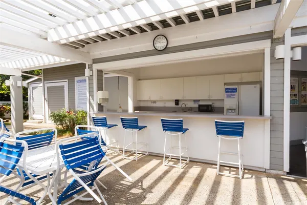 a view of patio with table and chairs and couches with wooden floor and fence