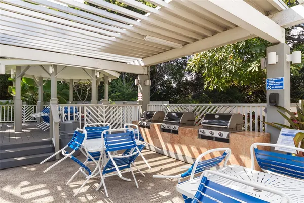 a view of a swimming pool with a lawn chairs and palm trees