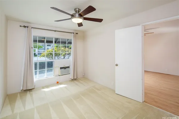 a view of a livingroom with a ceiling fan and kitchen view