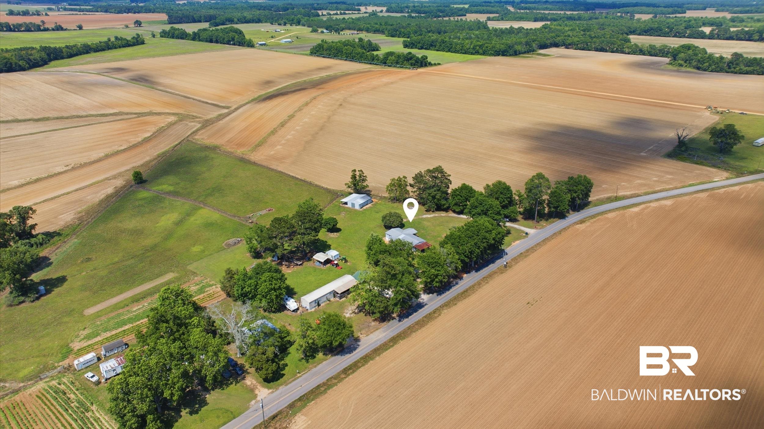 926 Tumbling Lane Atmore, AL 36502 - Photo 52 of 56 Expansive rural property featuring multiple structures, mature trees, and surrounding agricultural fields