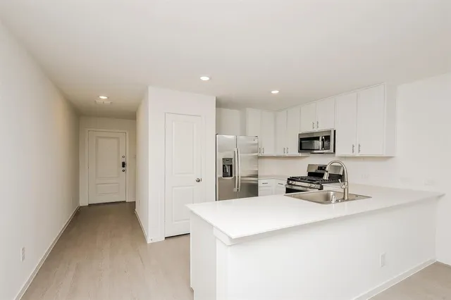 a kitchen with stainless steel appliances a refrigerator sink and microwave