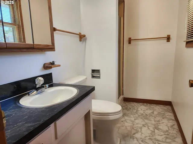 a bathroom with a granite countertop sink toilet and a mirror