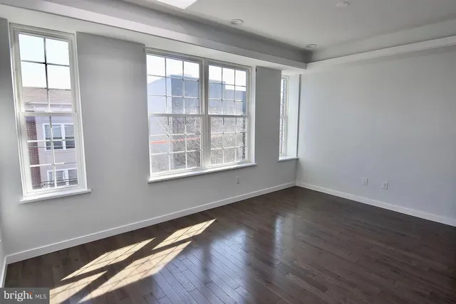 a view of an empty room with wooden floor