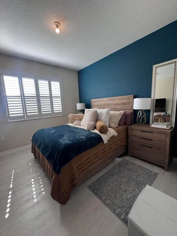 a bed sitting in a bedroom and view of living room