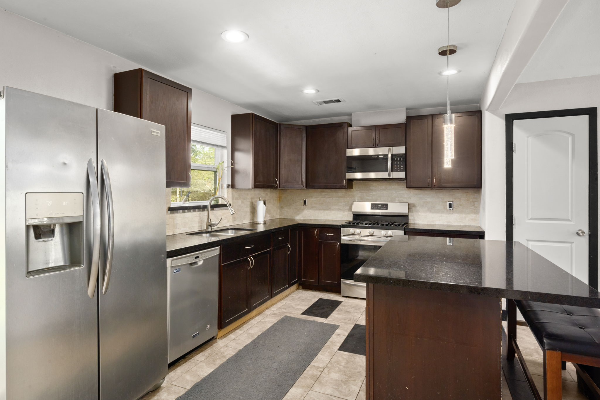 3414 Rustling Pines Street Spring, TX 77380 - Photo 9 of 26 a kitchen with stainless steel appliances granite countertop a refrigerator a sink a stove a microwave and a refrigerator