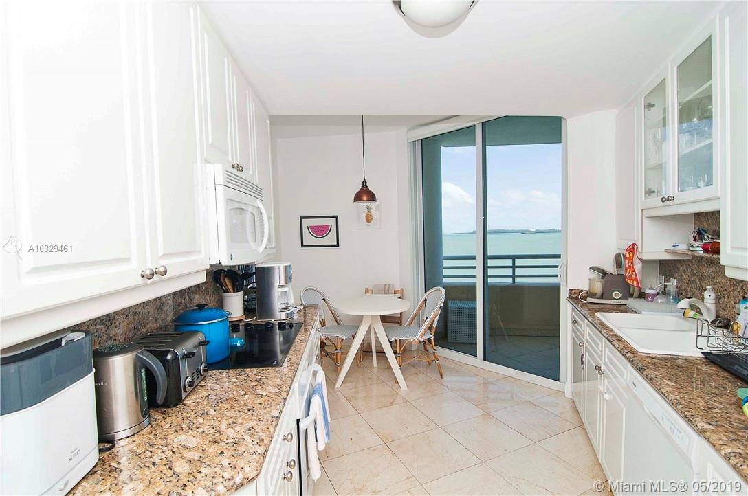 808 Brickell Key Drive, Unit 802 Miami, FL 33131 - Photo 9 of 48 A luxury kitchen with stunning bay views, balcony access, an eat-in area, newer appliances, and granite countertops.
