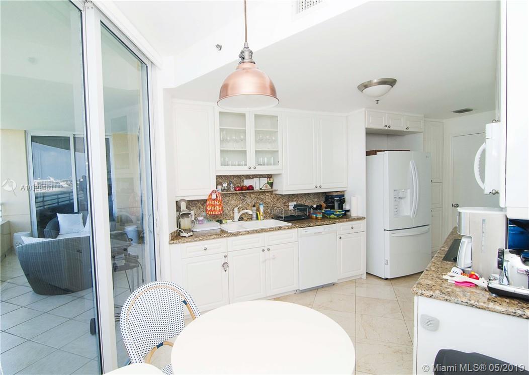 808 Brickell Key Drive, Unit 802 Miami, FL 33131 - Photo 10 of 48 A luxury kitchen with stunning bay views, balcony access, an eat-in area, newer appliances, and granite countertops.