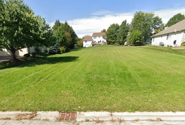 a view of a field of grass and trees