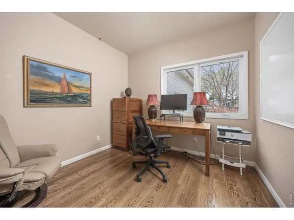 a view of a workspace with furniture and a window