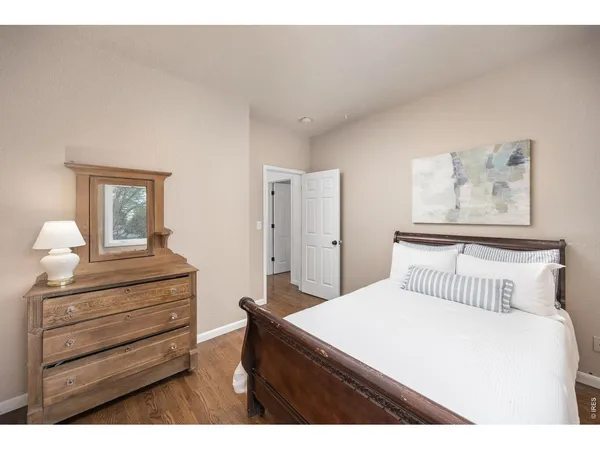 a bedroom with a bed and a painting on the wall