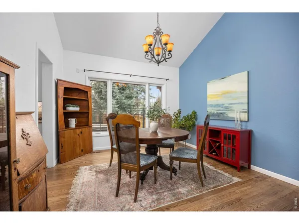 a view of a dining room and livingroom with furniture window and wooden floor