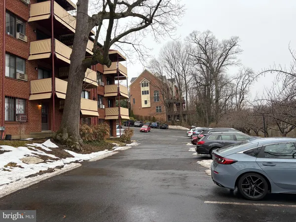 a front view of a building with lot of cars on road