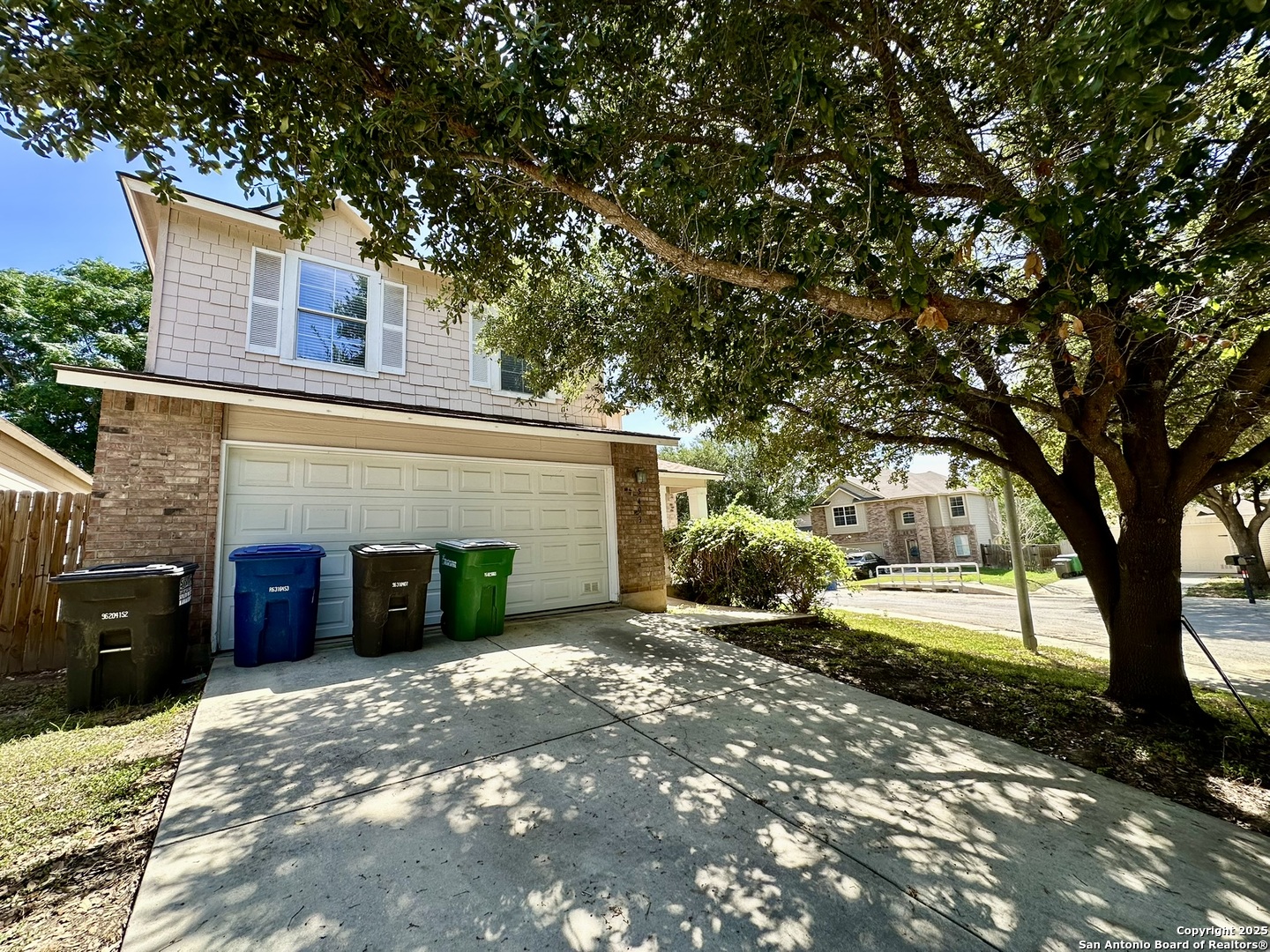 a view of a house with a yard and large tree