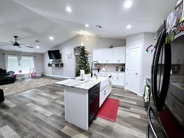 a kitchen with stainless steel appliances kitchen island granite countertop a sink stove and refrigerator