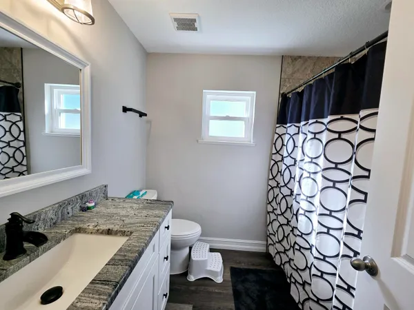 a bathroom with a granite countertop sink and a mirror