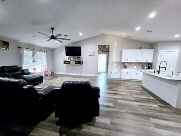 a living room with stainless steel appliances kitchen island granite countertop furniture and a view of kitchen