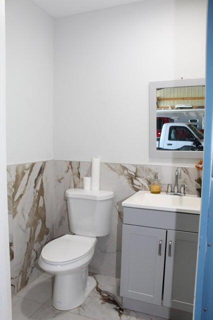 2410 South Brocksmith Road Fort Pierce, FL 34945 - Photo 45 of 65 a bathroom with a toilet a sink and a mirror