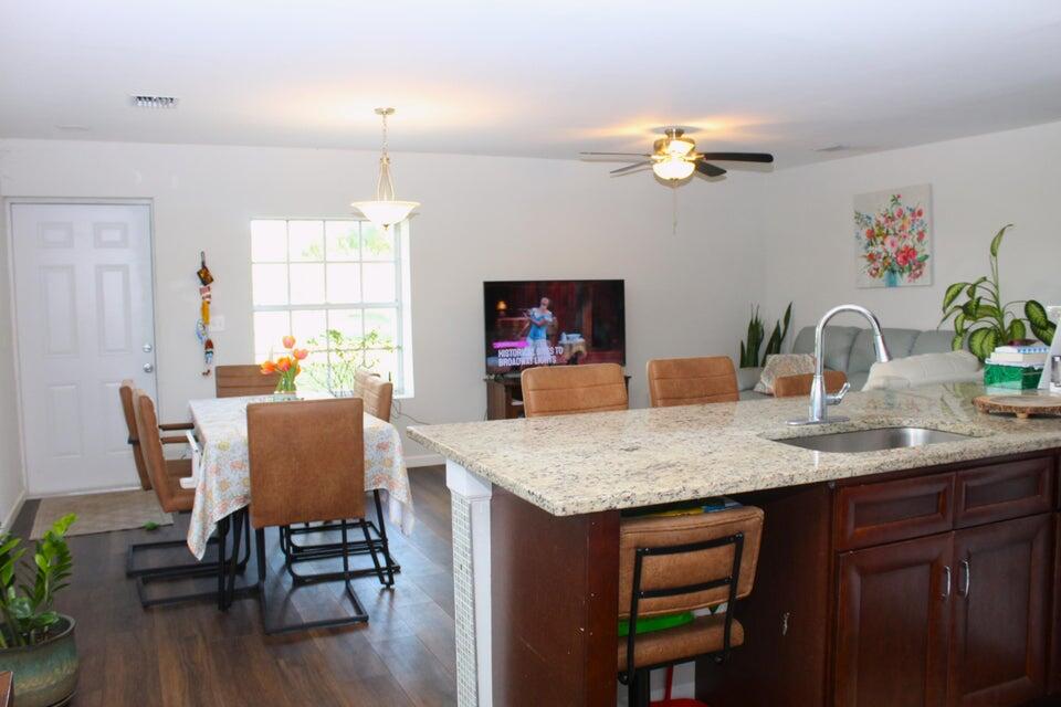 2410 South Brocksmith Road Fort Pierce, FL 34945 - Photo 49 of 65 a dining room with a table chairs and a chandelier