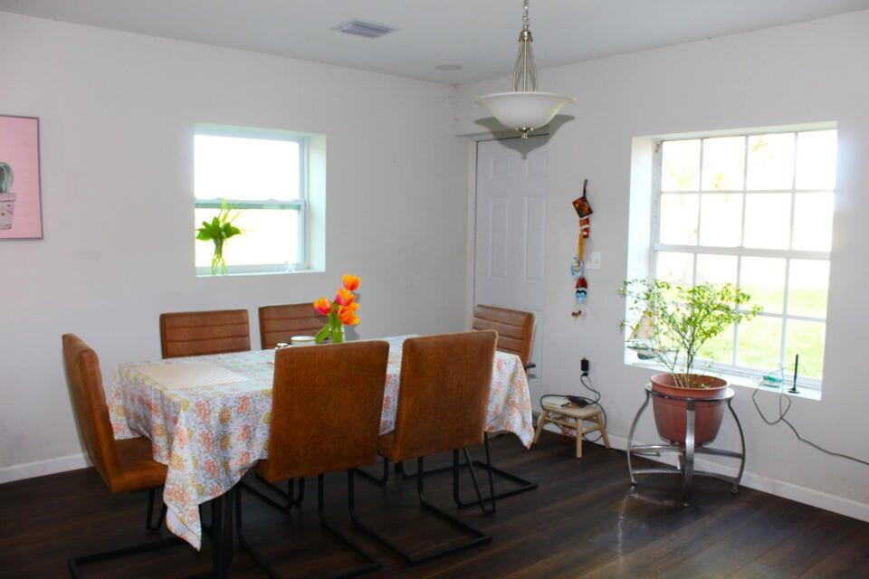 2410 South Brocksmith Road Fort Pierce, FL 34945 - Photo 57 of 65 a view of a dining room with furniture a chandelier and wooden floor