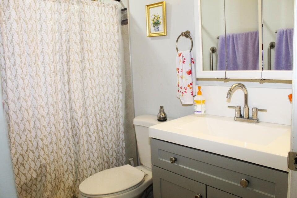 2410 South Brocksmith Road Fort Pierce, FL 34945 - Photo 64 of 65 a bathroom with a sink vanity mirror and toilet