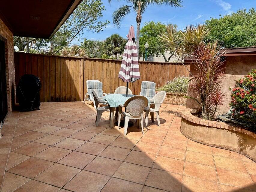 1420 Ocean Way, Unit 14D Jupiter, FL 33477 - Photo 26 of 34 a view of a chairs and table in patio with a lake