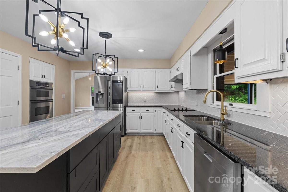 5916 Cashion Road Huntersville, NC 28078 - Photo 16 of 45 a large kitchen with granite countertop a large island in the center and stainless steel appliances