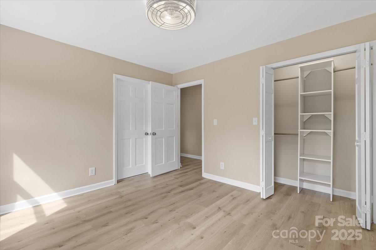 5916 Cashion Road Huntersville, NC 28078 - Photo 22 of 45 an empty room with wooden floor and closet