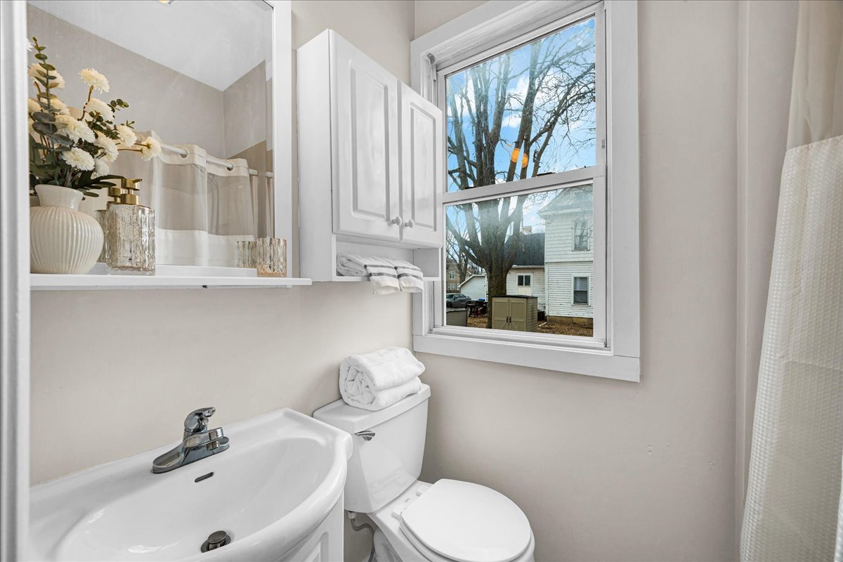 1018 North Prairie Street Bloomington, IL 61701 - Photo 12 of 49 a bathroom with a sink mirror and toilet