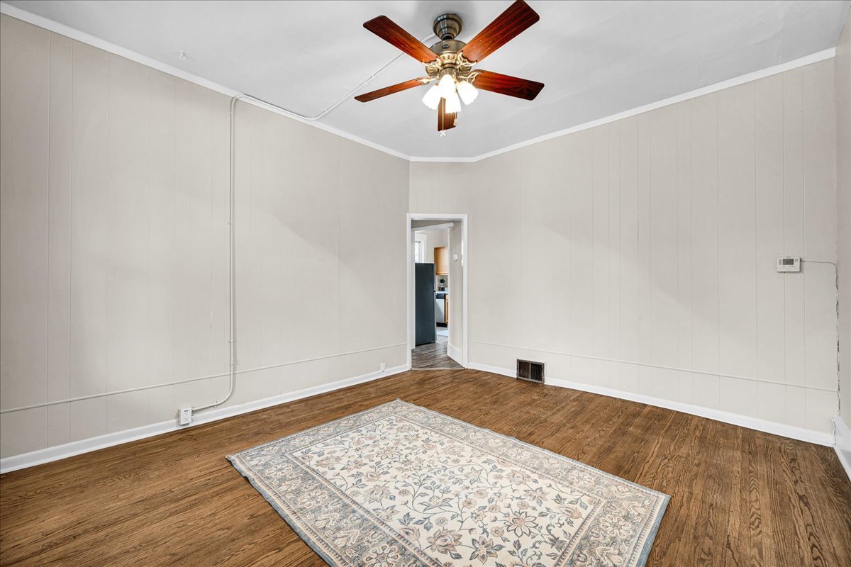 1018 North Prairie Street Bloomington, IL 61701 - Photo 2 of 49 an empty room with wooden floor and a ceiling fan