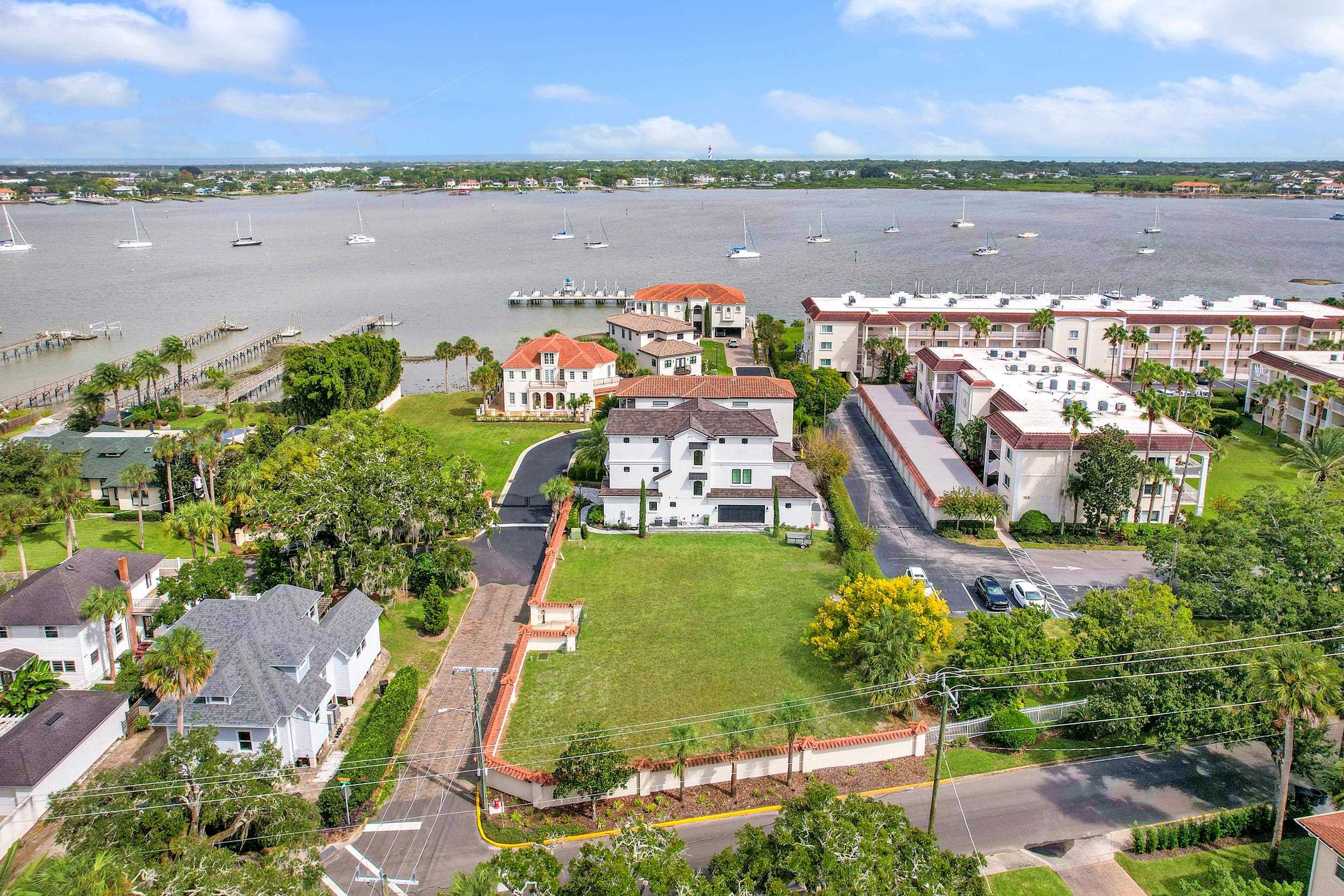an aerial view of a city with lots of residential buildings ocean and mountain view in back
