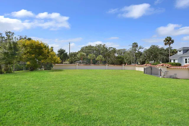 a backyard of a house with lots of green space and trampoline