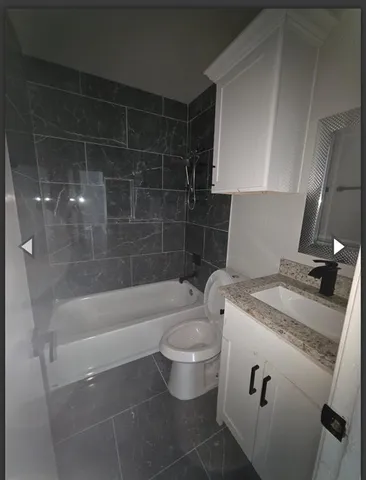 a bathroom with a granite countertop sink a toilet and bathtub