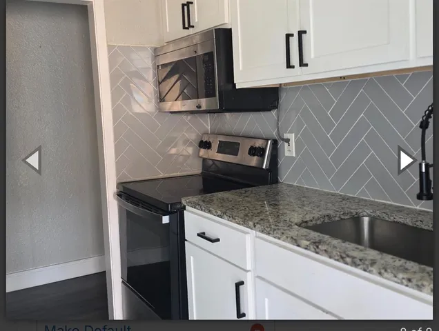 a kitchen with stainless steel appliances granite countertop a sink and a microwave