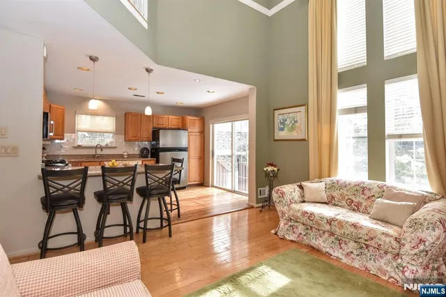 a kitchen with kitchen island granite countertop a refrigerator stove microwave and white cabinets